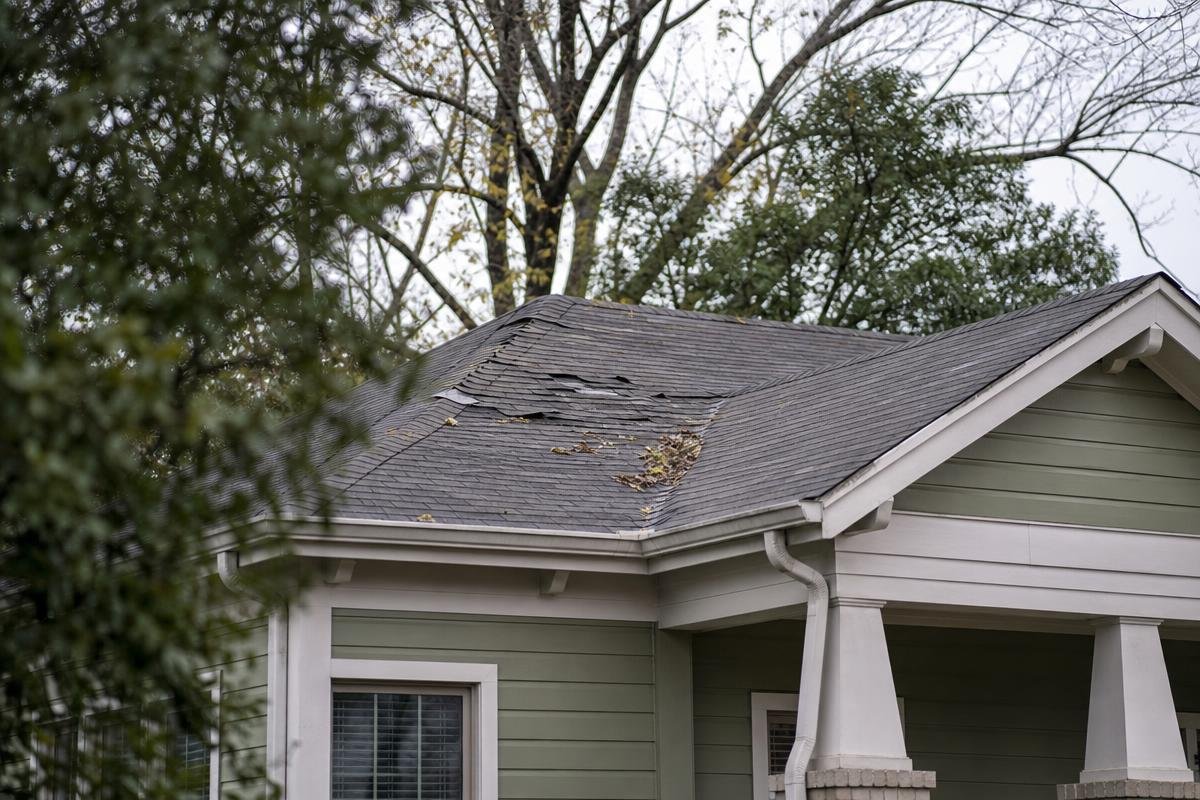 roofing company Spartanburg SC inspecting storm-damaged shingles